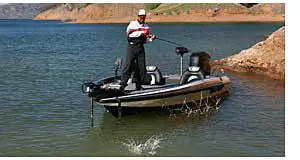 Bass Boat With Angler Catching A Fish