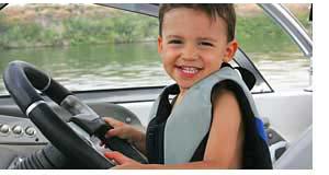 Young Boy Driving A Boat